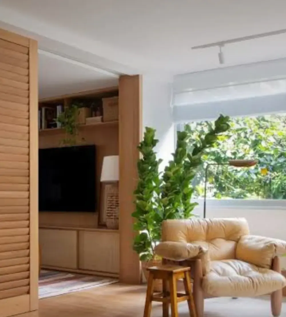 Imagem ilustrativa: sala com painel de madeira, estante, poltrona de couro e plantas junto à janela